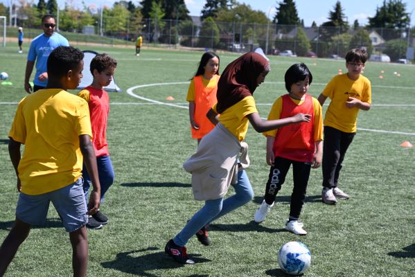 Un groupe d’enfants joue au soccer en plein air.