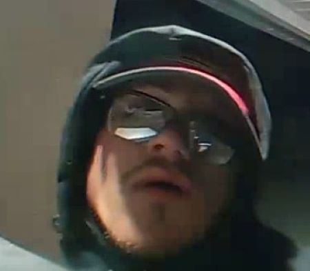 A close up coloured image of the suspect with a hood up. 