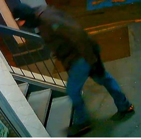Suspect 2 : un homme vêtu d’une veste foncée et d’un pantalon bleu monte une cage d’escalier. 