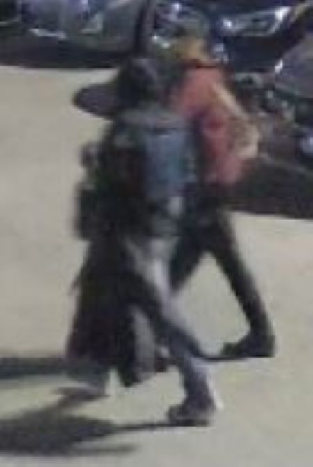Deux personnes suspectes traversent un parc de stationnement. Selon la description, la première personne suspecte est entièrement vêtue de noir et a un capuchon marron; la deuxième personne suspecte porte une veste noir et blanc de style Adidas et un jean bleu. 